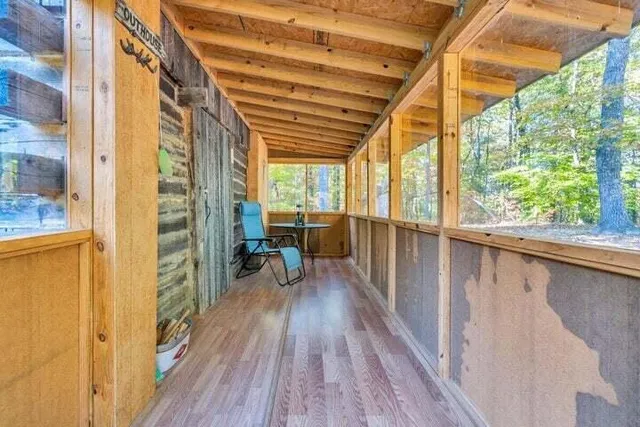 a backyard of a house with wooden fence and a large tree