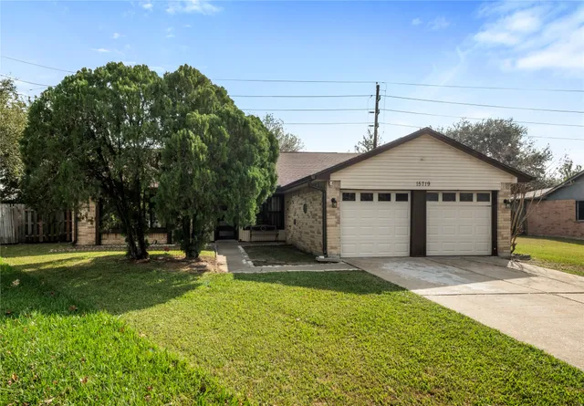 a big white house with a big yard and large trees with wooden fence