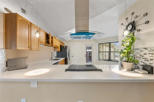 a kitchen with stainless steel appliances granite countertop a sink a stove and a refrigerator