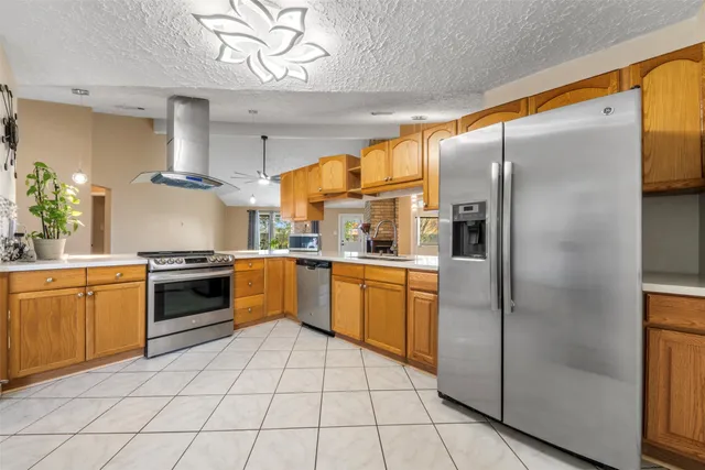 a kitchen with stainless steel appliances granite countertop a refrigerator a sink dishwasher with a stove and cabinets