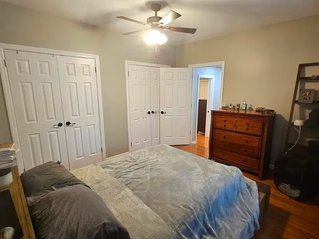 a bed room with a bed and a ceiling fan
