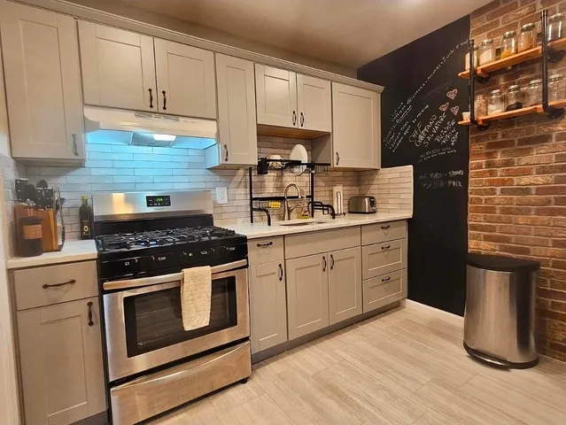 a kitchen with a stove cabinets and wooden floor