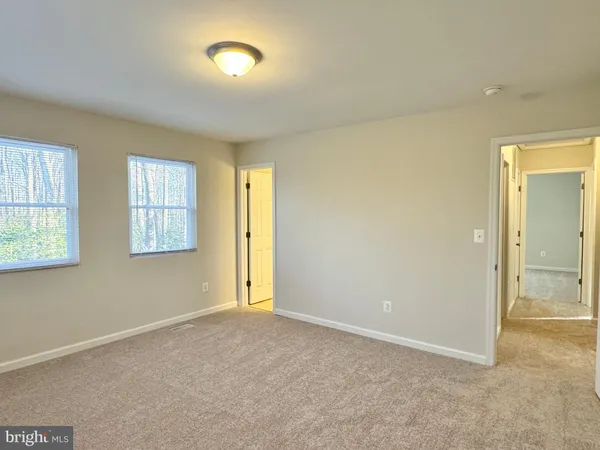 an empty room with windows and closet
