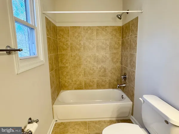 a bathroom with a toilet and bathtub