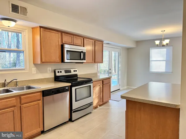 a kitchen with stainless steel appliances granite countertop a sink stove and microwave