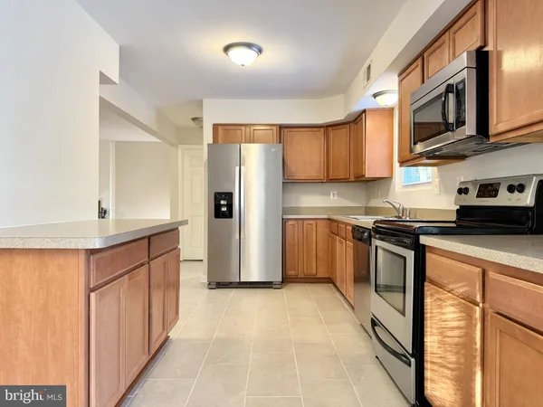 a kitchen with stainless steel appliances granite countertop a refrigerator and a stove top oven