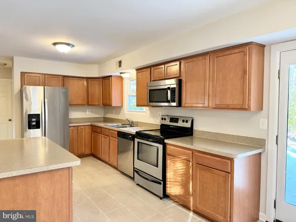 a kitchen with stainless steel appliances granite countertop a refrigerator stove microwave and sink