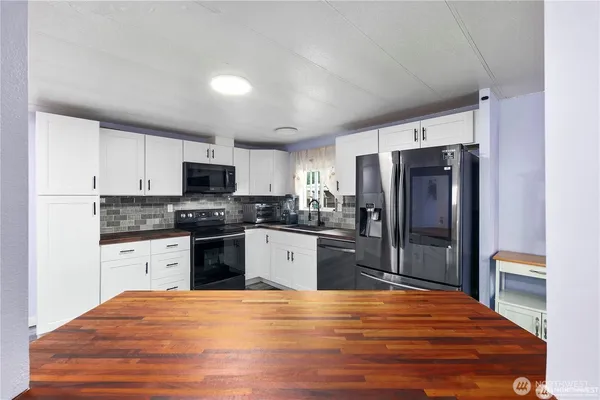 a kitchen with granite countertop a refrigerator stove top oven and sink