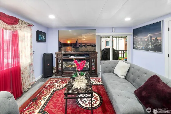 a living room with furniture a flat screen tv and a fireplace