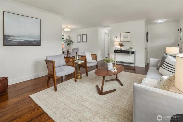 a living room with furniture and a painting on the wall