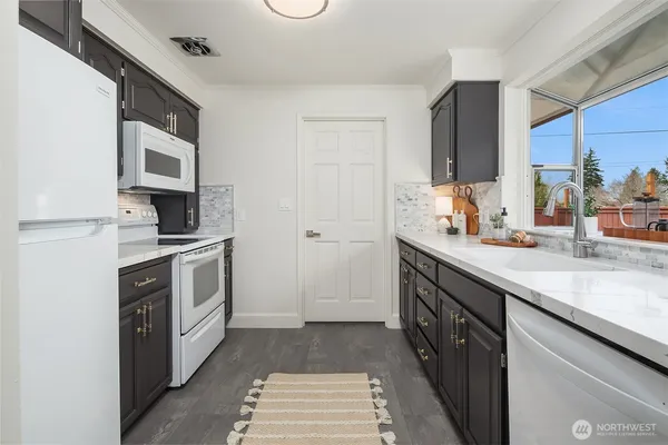 a kitchen with stainless steel appliances a sink stove and cabinets