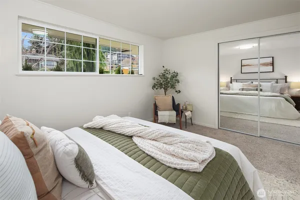 a bedroom with a bed and a large window