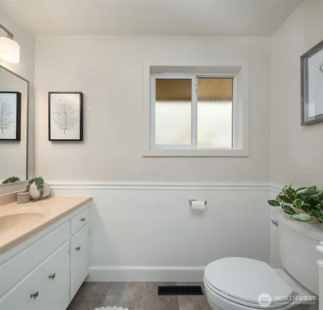 a bathroom with a toilet a sink a vanity and mirror