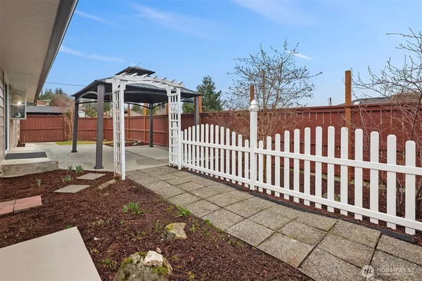 a view of a white house with wooden fence