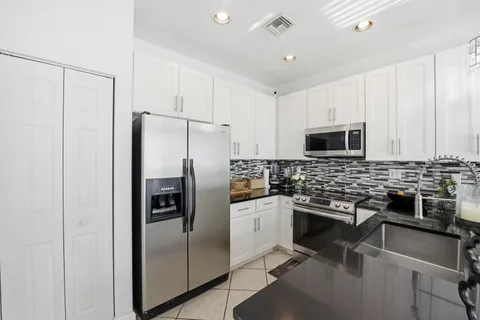 a kitchen with stainless steel appliances granite countertop a refrigerator and a stove top oven