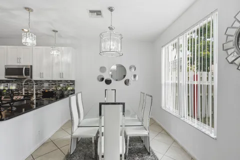a kitchen with stainless steel appliances a dining table chairs and a chandelier