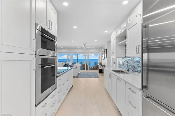 a large white kitchen with stainless steel appliances