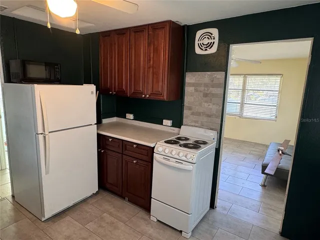 a kitchen with a refrigerator a stove top oven a washer and a sink