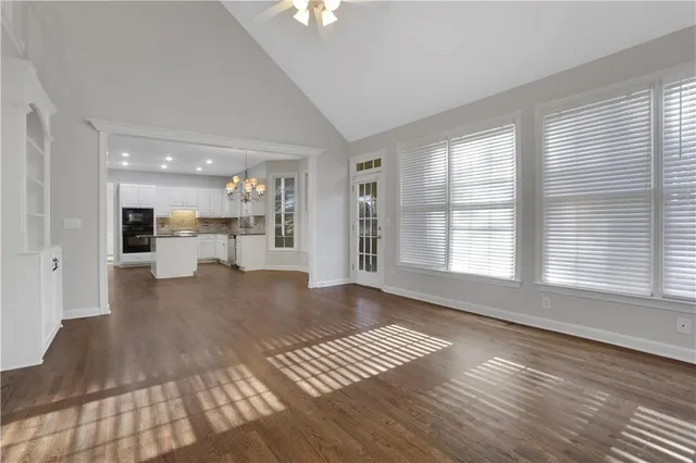 an empty room with chandelier fan