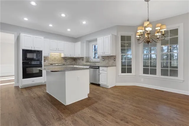 a view of empty room with wooden floor and window