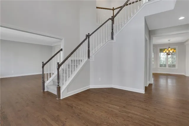 a kitchen with stainless steel appliances granite countertop a sink dishwasher and a refrigerator with wooden floor