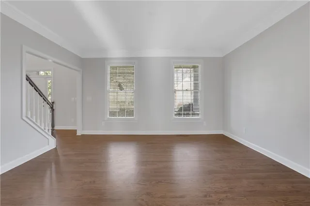 a kitchen with stainless steel appliances granite countertop a stove a sink dishwasher a refrigerator and a dining table with wooden floor