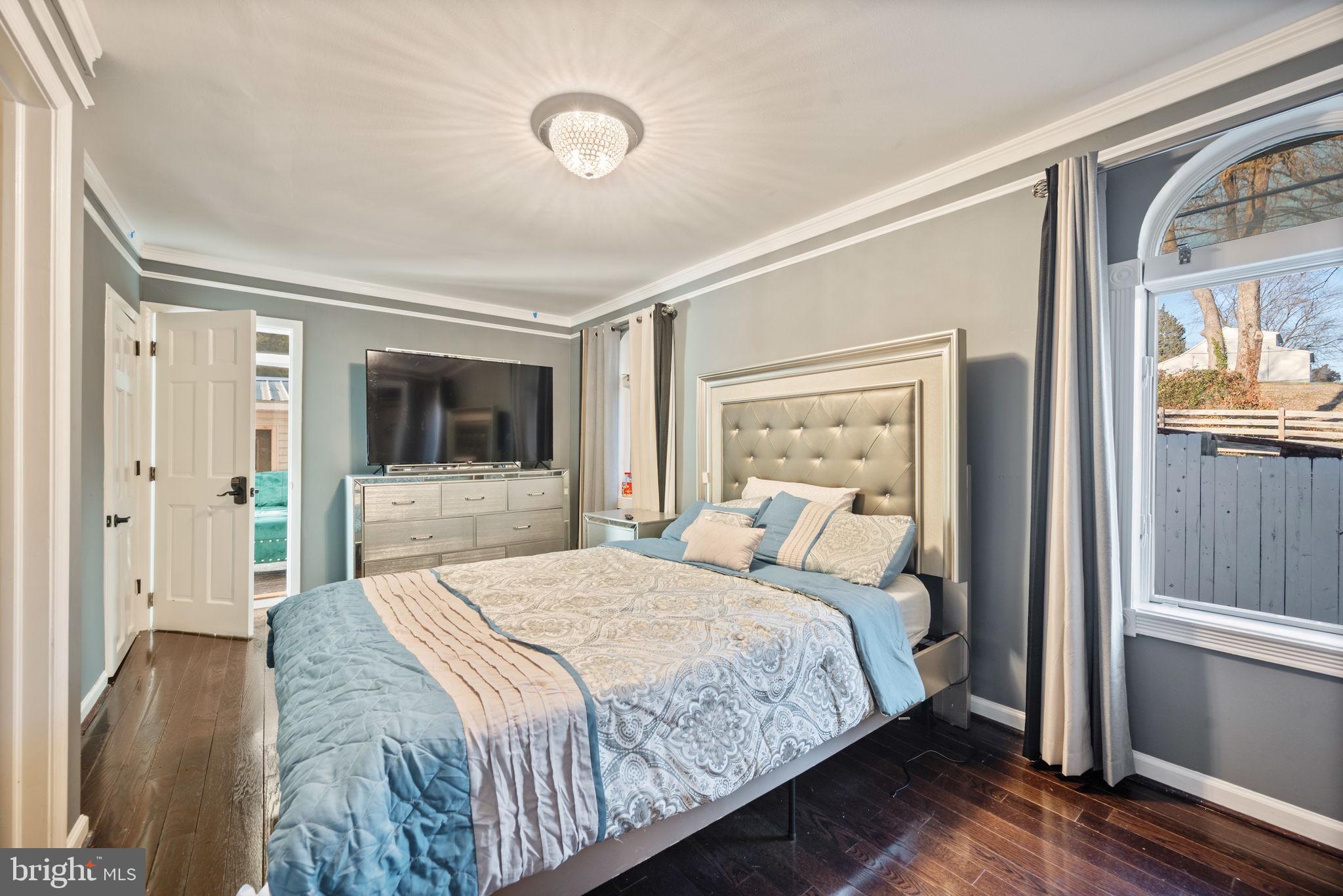 7902 Bridge Avenue Baltimore, MD 21237 - Photo 12 of 28 a bedroom with a large bed and a flat screen tv