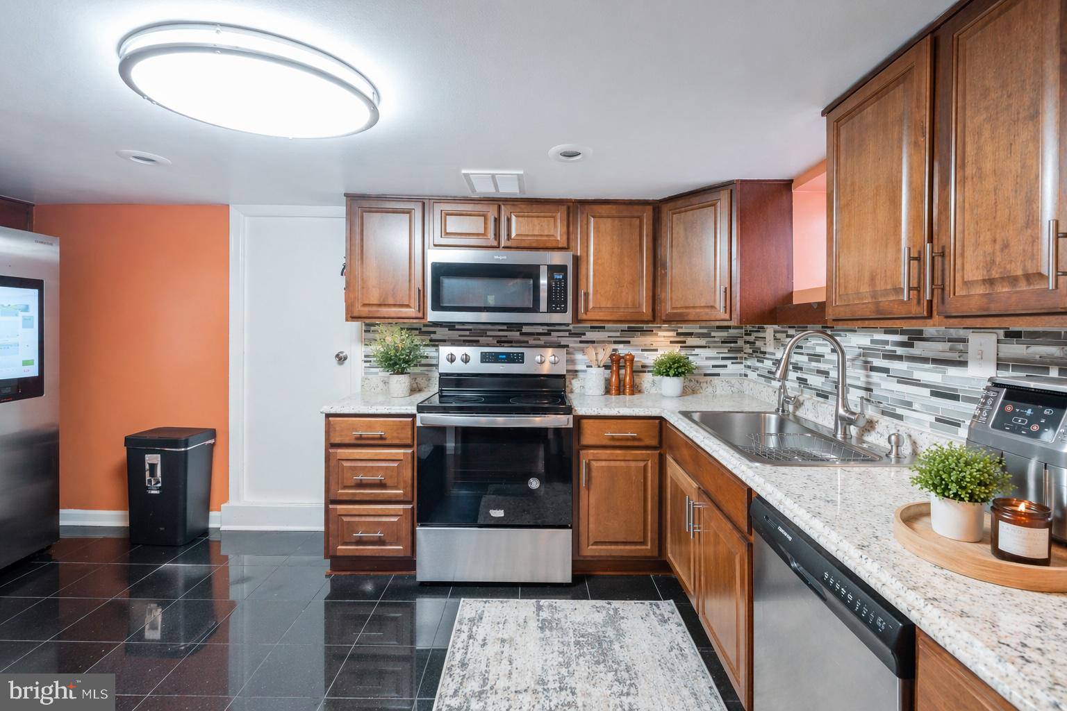 7902 Bridge Avenue Baltimore, MD 21237 - Photo 4 of 28 a kitchen with stainless steel appliances granite countertop a stove a sink and a microwave