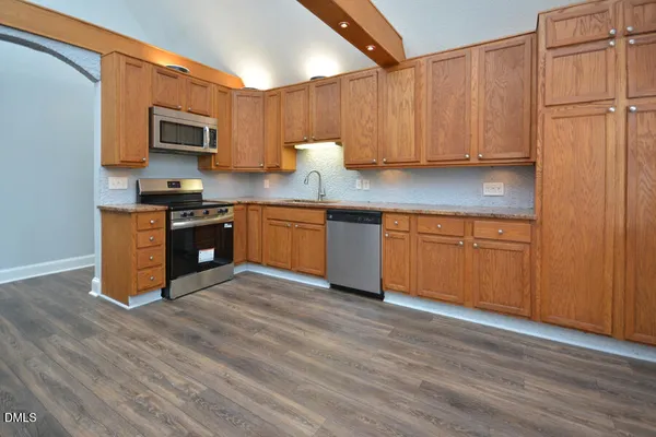 a kitchen with stainless steel appliances granite countertop a refrigerator and a stove top oven