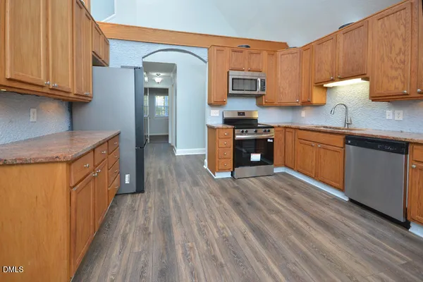 a kitchen with granite countertop a stove top oven microwave and cabinets