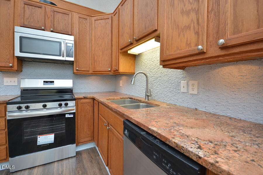220 Bill Poole Road Rougemont, NC 27572 - Photo 17 of 63 a kitchen with granite countertop a stove top oven microwave and cabinets