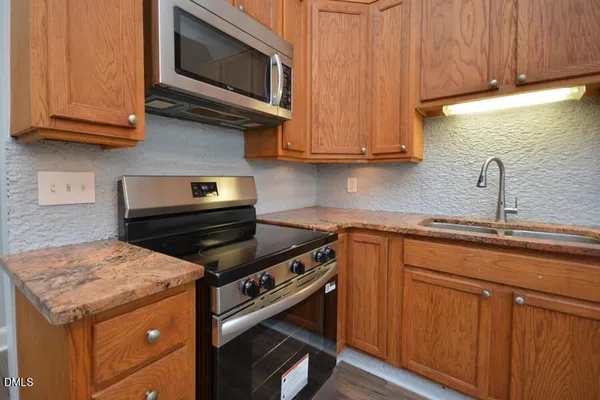 a kitchen with granite countertop wooden cabinets and a sink