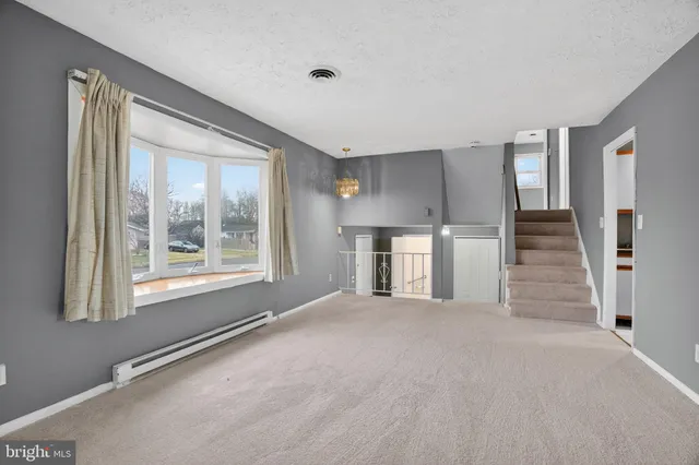a view of empty room with stairs and windows
