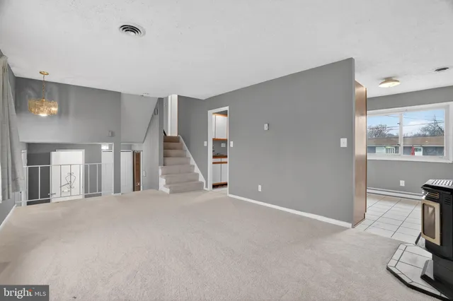 a view of a livingroom with a flesh screen tv and stairs
