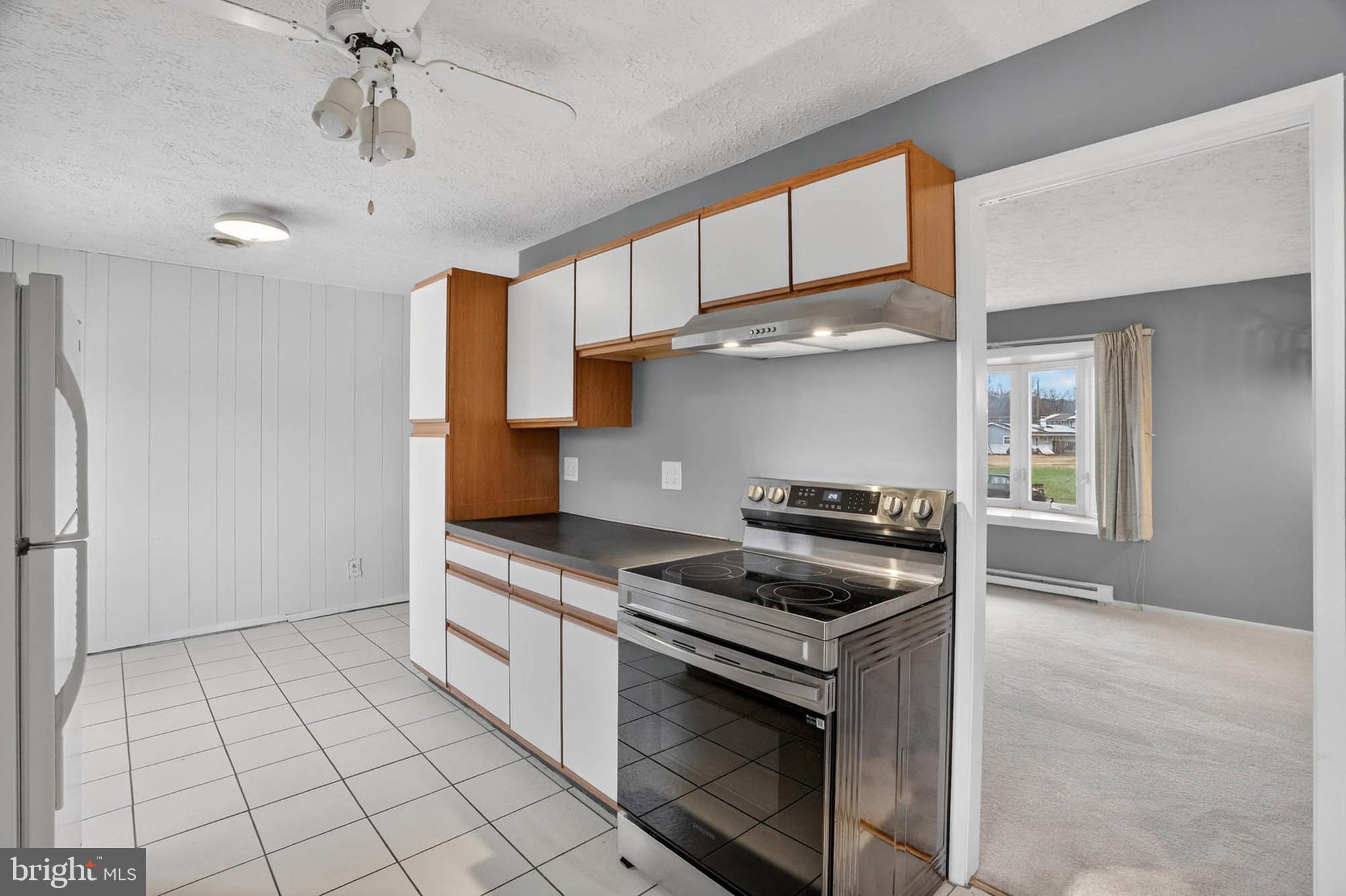 704 Ferguson Road Joppa, MD 21085 - Photo 18 of 30 a kitchen with granite countertop a stove a sink and a refrigerator