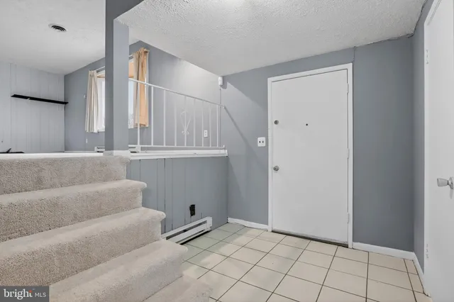 a view of an empty room with wooden floor and cabinet