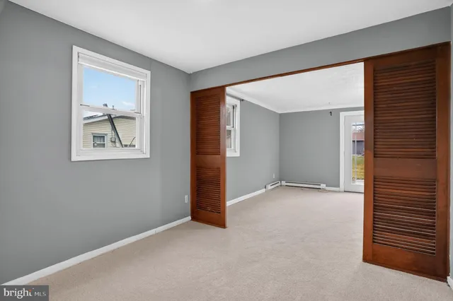 an empty room with windows and closet