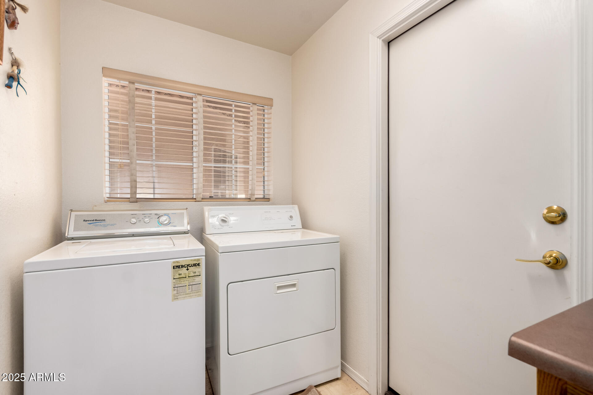 14806 West Verde Lane Goodyear, AZ 85395 - Photo 27 of 30 a view of washer and dryer with bathroom in the background