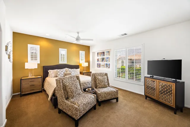 a bedroom with furniture and a flat screen tv