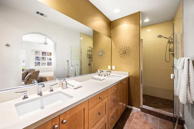a bathroom with a double vanity sink mirror and shower
