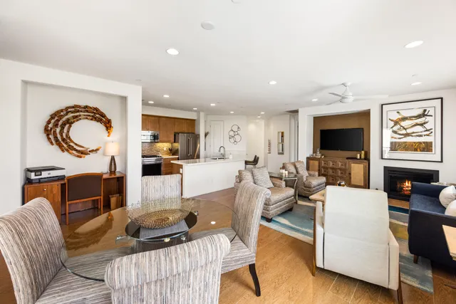 a living room with furniture a flat screen tv and kitchen view