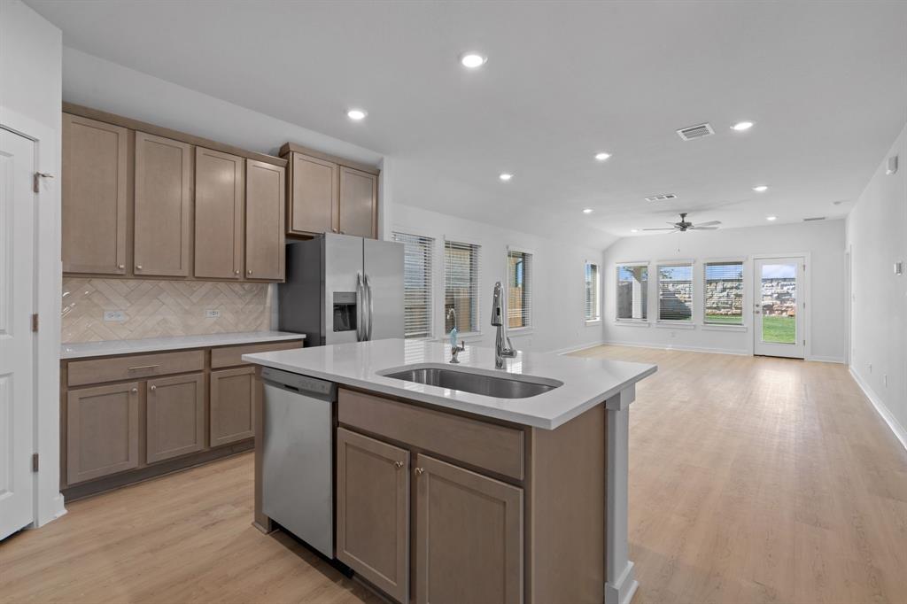 212 Brandywine Road Hutto, TX 78634 - Photo 34 of 35 Kitchen featuring tasteful backsplash, appliances with stainless steel finishes, recessed lighting, light wood-style floors, and open floor plan