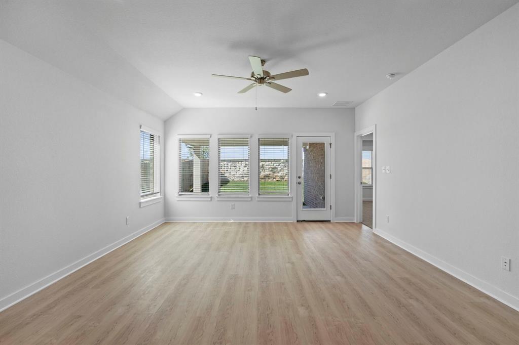 212 Brandywine Road Hutto, TX 78634 - Photo 7 of 35 Unfurnished room featuring light wood finished floors, a ceiling fan, lofted ceiling, and recessed lighting