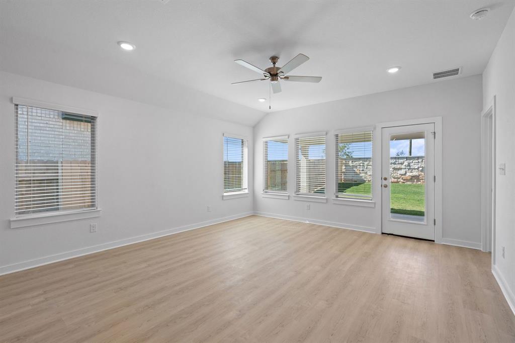 212 Brandywine Road Hutto, TX 78634 - Photo 8 of 35 Spare room featuring light wood finished floors, a ceiling fan, vaulted ceiling, and recessed lighting