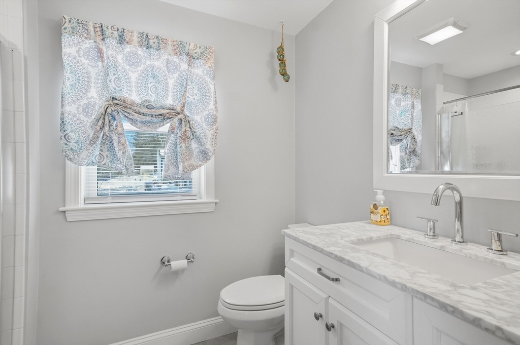 24 Holly Street Billerica, MA 01821 - Photo 15 of 33 a bathroom with a granite countertop sink a toilet and a mirror