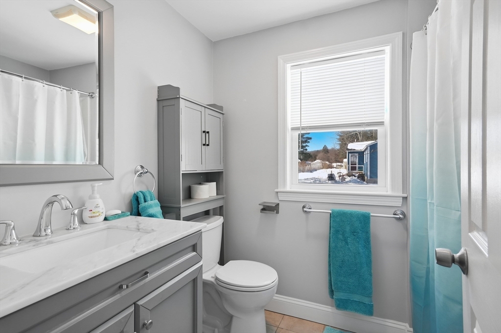24 Holly Street Billerica, MA 01821 - Photo 19 of 33 a bathroom with a granite countertop toilet sink and mirror
