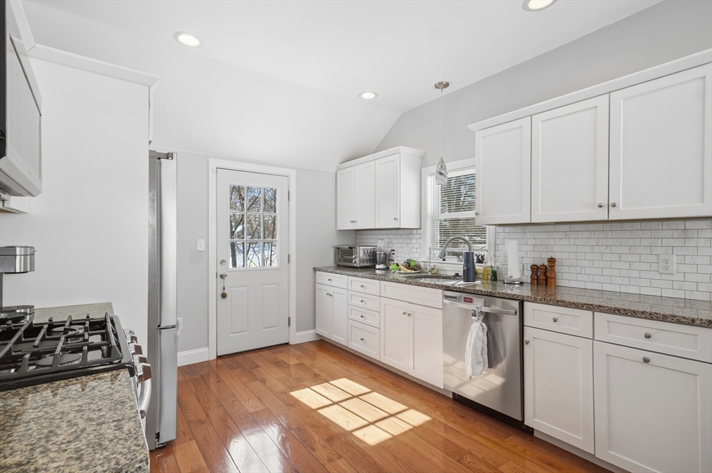 24 Holly Street Billerica, MA 01821 - Photo 7 of 33 a kitchen with stainless steel appliances granite countertop a stove a sink and white cabinets