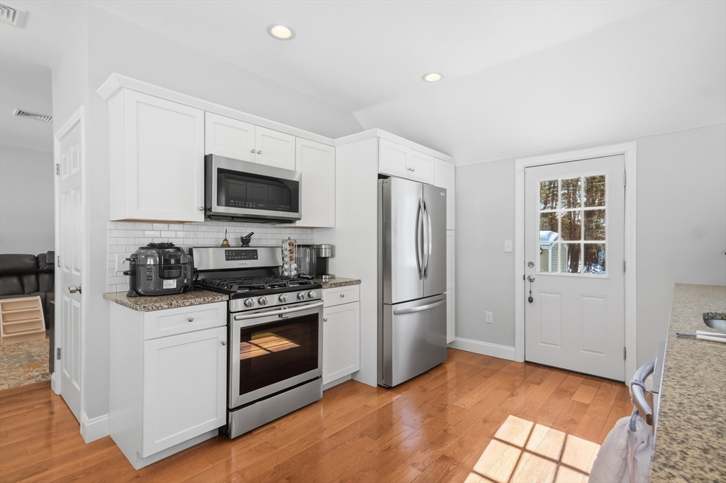 24 Holly Street Billerica, MA 01821 - Photo 8 of 33 a kitchen with stainless steel appliances granite countertop a stove a refrigerator and a microwave
