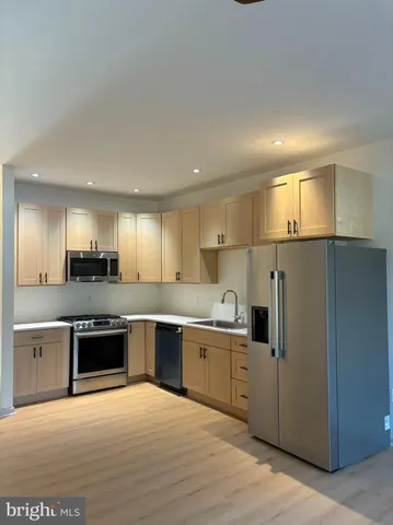 a large kitchen with cabinets and stainless steel appliances