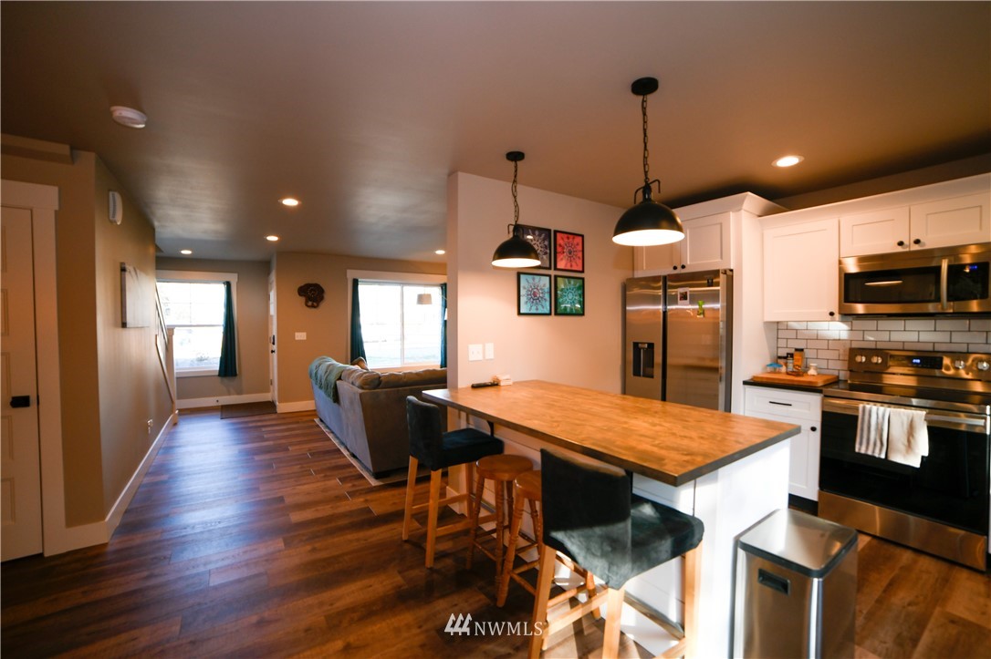 202 St Helens Way Winlock, WA 98596 - Photo 4 of 25 a kitchen with stainless steel appliances kitchen island granite countertop a table chairs and a wooden floor